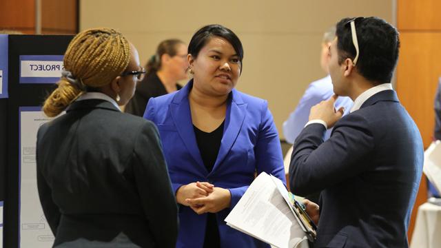 Three 赌钱app可以微信提现 students conversing at a reverse career fair.